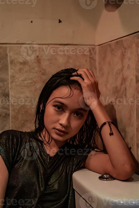Hot and wet Asian girl poses with sensual style while wearing black wet ...