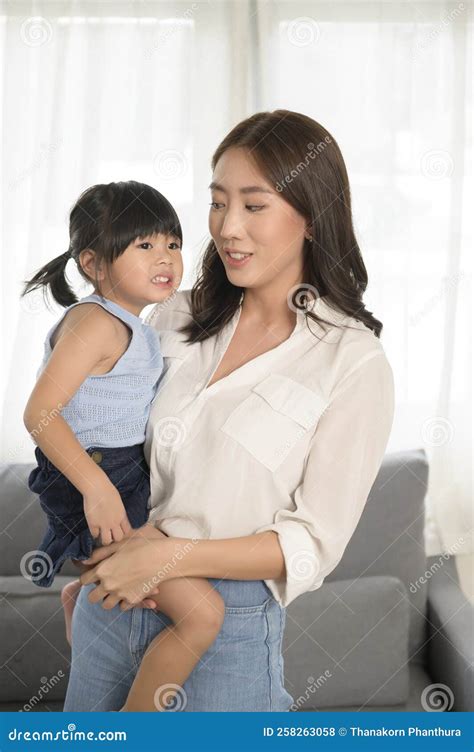 Portrait of Asian Mom and Little Girl Smiling on Sofa at Home Stock Photo - Image of care ...