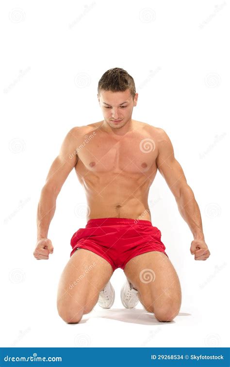 Portrait of Young Muscular Man on His Knees Stretching Stock Photo ...