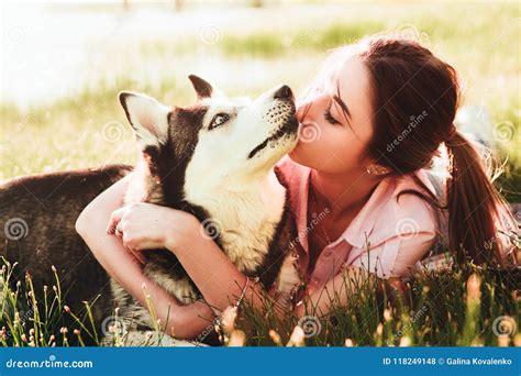 A Girl is Kissing a Dog of the Breed of Husky. Stock Photo - Image of ...