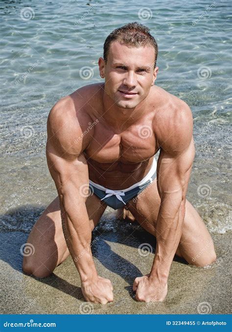 Attractive Muscular Young Man on His Knees on the Beach Stock Image ...