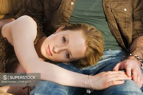 Woman laying head on boyfriend's lap - SuperStock