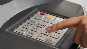 Hand Entering Pin Code on ATM Keypad