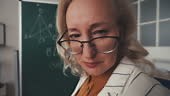 Funny strict mathematics teacher in her 50s looking at camera,...