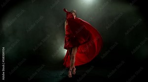 Brunette Woman in Ruby Red Dress Posing Against a Black Background . Filmed on High Speed Cinematic Camera in Super Slow Motion