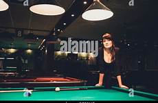table billiard busty brunette playing woman young beautiful red indoors toned atmosphere warm natural light alamy