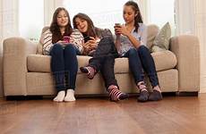 sitting sofa girls teenage looking phones dissolve cultura d943