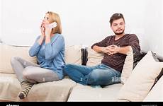 cheating wife phone while husband privately waits talking alamy