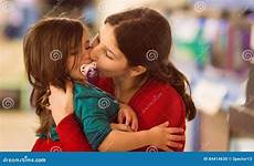 kissing girl young sister her cheek holding portrait stock