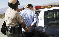 man police arrest apprehended guiding officer rear into car shutterstock
