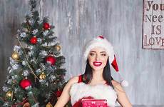 meisje kerstman vertellen kerstboom wens oor kleren mooi draagt glimlachende vrouw