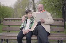man old reading boy sitting grandson grandfather park bench book family leisure generations outdoors friendly concept