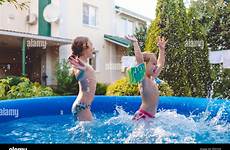 pool little playing fun backyard alamy cute sisters splashing two inflatable having jumping cheerful stock