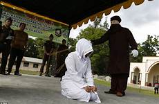 woman adultery caned before kneel indonesian law being indonesia forced whipped kneeling punishment sharia down enforcer masked brutally canned her