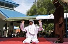 punishment woman adultery brutal caned indonesia man hands person forced outside being arms her where lashed falling wrong she times