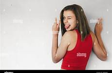 tongue stiking winking short teen funny red girl top fingers victory concrete against making sign wall her alamy