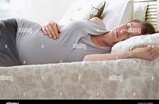 pregnant woman sleeping bed alamy