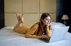 bed laying woman using laptop d145 caucasian stock