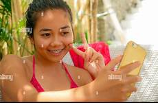 asian girl bikini bed selfie indonesian teenager sarong relaxed sitting taking alamy pool mobile phone happy young beautiful