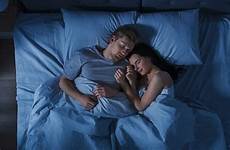 bed cuddling couple sleeping night together happy young girl boy each other shot top stock