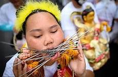 festival piercing cheeks vegetarian phuket chinese skewers thai devotees through their needles pierced face impale shrine procession part annual gruesome