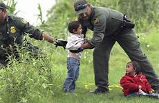 border patrol children agents rescue migrant young carrizo honduras agent rio grande texas cane lined onto grassy shore lift tall