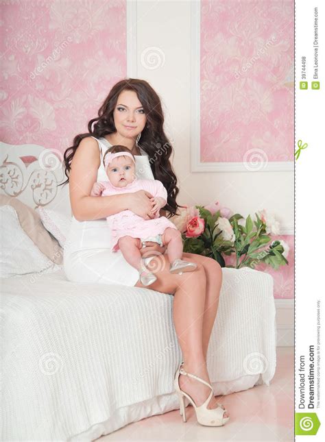 Lassen sich die flecken wegwischen? Mutter Im Weißen Kleid, Das Mit Baby Auf Stuhl Sitzt ...