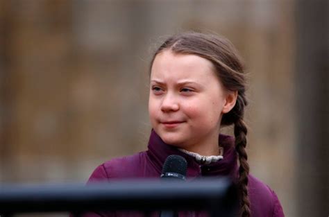 Photo of greta thunberg sitting in front of mountains and lake. Greta Thunberg trauert um ihren Großvater