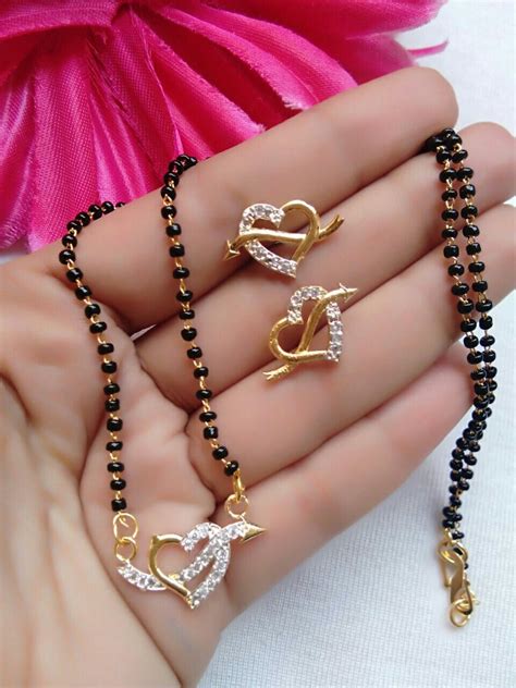 The pendant is beautifully encrusted with 55 gleaming diamonds with alternate design of squares and flowers sparkling with superb radiance. Magalsutra (With images) | Black beaded jewelry, Gold ...