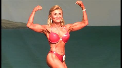 8 in front of the woman there's a table, and a vase with flowers in it. 63 Year Old Female Bodybuilder at The 2013 Europa Show of ...
