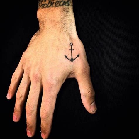 Le tatouage est un dessin décoratif permanent sur votre corps. petit tatouage homme jolie ancre marine sur la main ...