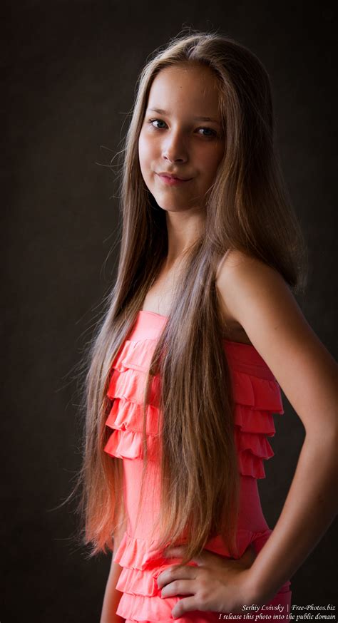 Female with glasses in casual clothes, smiling, background city park,tree, grass, meadow. Photo of a pretty 13-year-old girl photographed in July ...