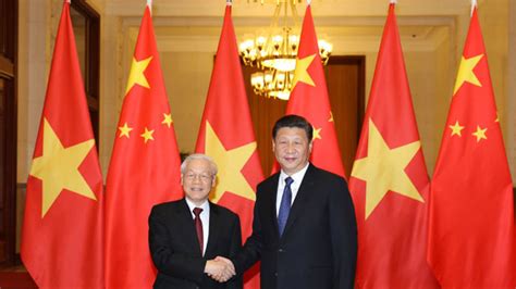 Chinese president xi jinping (c) and vietnam's communist party secretary general nguyen phu trong (r) wave during a welcoming ceremony at the presidential palace in hanoi on november 12, 2017. Nguyen Phu Trong's Dual Role Will Help Vietnam Development, Boost China Ties - Left Review Online