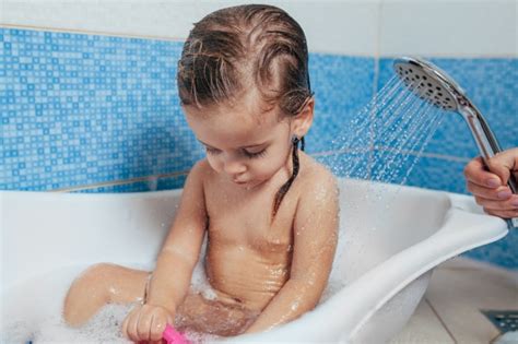 Baby bath — understand the basics, from testing water temperature to holding your newborn securely. Free Photo | Cute baby playing with rubber toy duck while ...