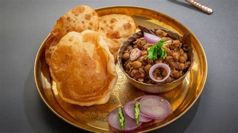 Chole bhature is a combination of chickpea curry served with deep fried flour pooris. The Magic of Chole Bhature