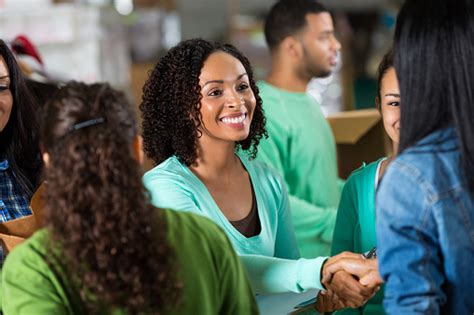 The food bank of the southern tier's warehouse receives and distributes millions of pounds of food every year. Female Volunteer Greets Woman In Food Bank Stock Photo ...