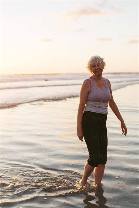 Vibrant Mature Woman Enjoying Herself On The Beach At Sunset by Rob And ...