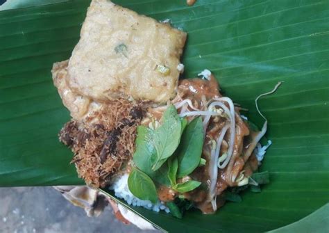 Taburan petai cina (lamtoro), daun pepaya, serundeng kelapa, dan kacang goreng, melengkapi paduan sayuran rebus. Resep Pecel Pincuk Madiun - Tata nasi di pincuk daun pisang.