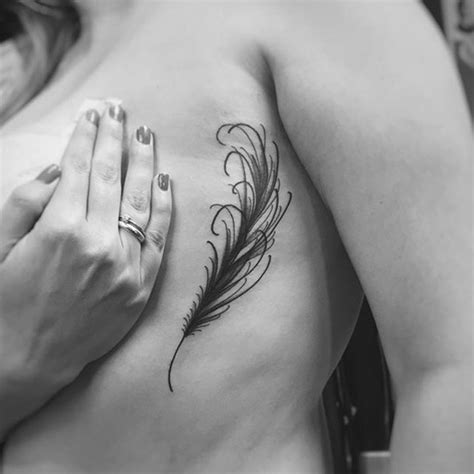 The small feather tattoo is among the popular design in tattoos due its aesthetic beauty and ease to adapt to different body parts, getting perfectly in. small-feather-tattoo-on-side - TatuaggiStyle.it