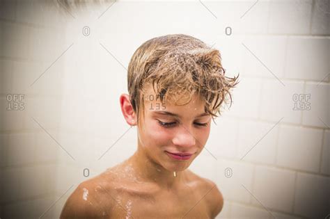 Users are prohibited from posting any material depicting individuals under the age of 18. Boy under the shower stock photo - OFFSET