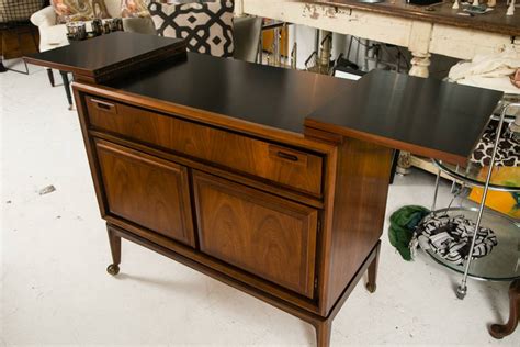 A collectors item and piece of design history, this stunning liquor cabinet was handcrafted with patinated pieces of copper, brass, and pewter which have been artistically welded and nailed in a patchwork style resting on a matching plinth base atop casters, allowing the cabinet to be easily. Mid-Century Custom Flip-Top Bar Cabinet at 1stdibs