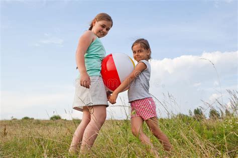 Your teen can play climate challenge here. Young Girls Playing With A Ball Outdoors Stock Photo ...