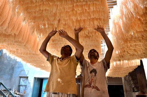 Women making colourful designs on their hands with pigments derived from hena leaves, going to the graves of deceased relatives to pray for them, and. Workers busy in arranging vermicelli to be used in Eid-ul ...