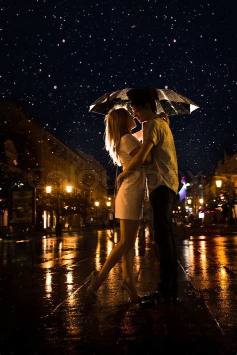 Couples kissing in the rain. Love in the rain / Silhouette of kissing couple under ...