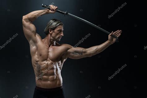 Мускулистый мужчина-модель в студии с мечом — Стоковое фото © ibrak ...