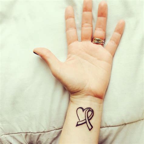 Another interesting take on cancer ribbon tattoos is making the ribbon appear as one half of a heart. female tattoo (With images) | Cancer ribbon tattoos ...