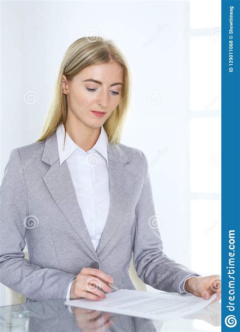 Blonde Business Woman Examining Contract While Sitting At The Glass ...