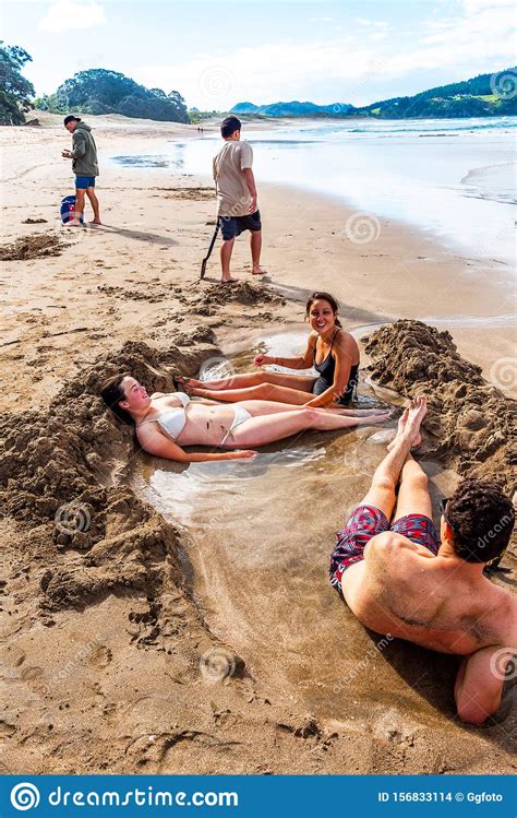 Recycled/recyclable printed on paper that contains at least 50% recycled fiber. COROMANDEL, NEW ZEALAND - OCTOBER 13, 2018: Tourists Dig ...