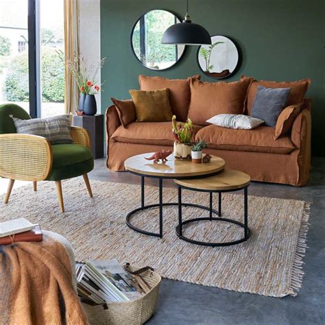 Le canapé lin présente un design bicolore avec une finition naturelle noire, ses accoudoirs et son assise sont en rotin tressé à la main par des artisans spécialisés. Canapé en lin : 18 modèles chics et intemporels