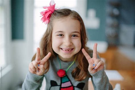 Cute Young Girl Showing The Peace Sign With Her Hands by Jakob ...